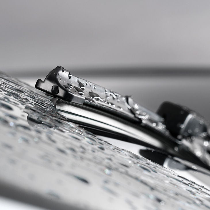 Nahaufnahme eines Audi-Scheibenwischers mit Wassertropfen auf der Windschutzscheibe.