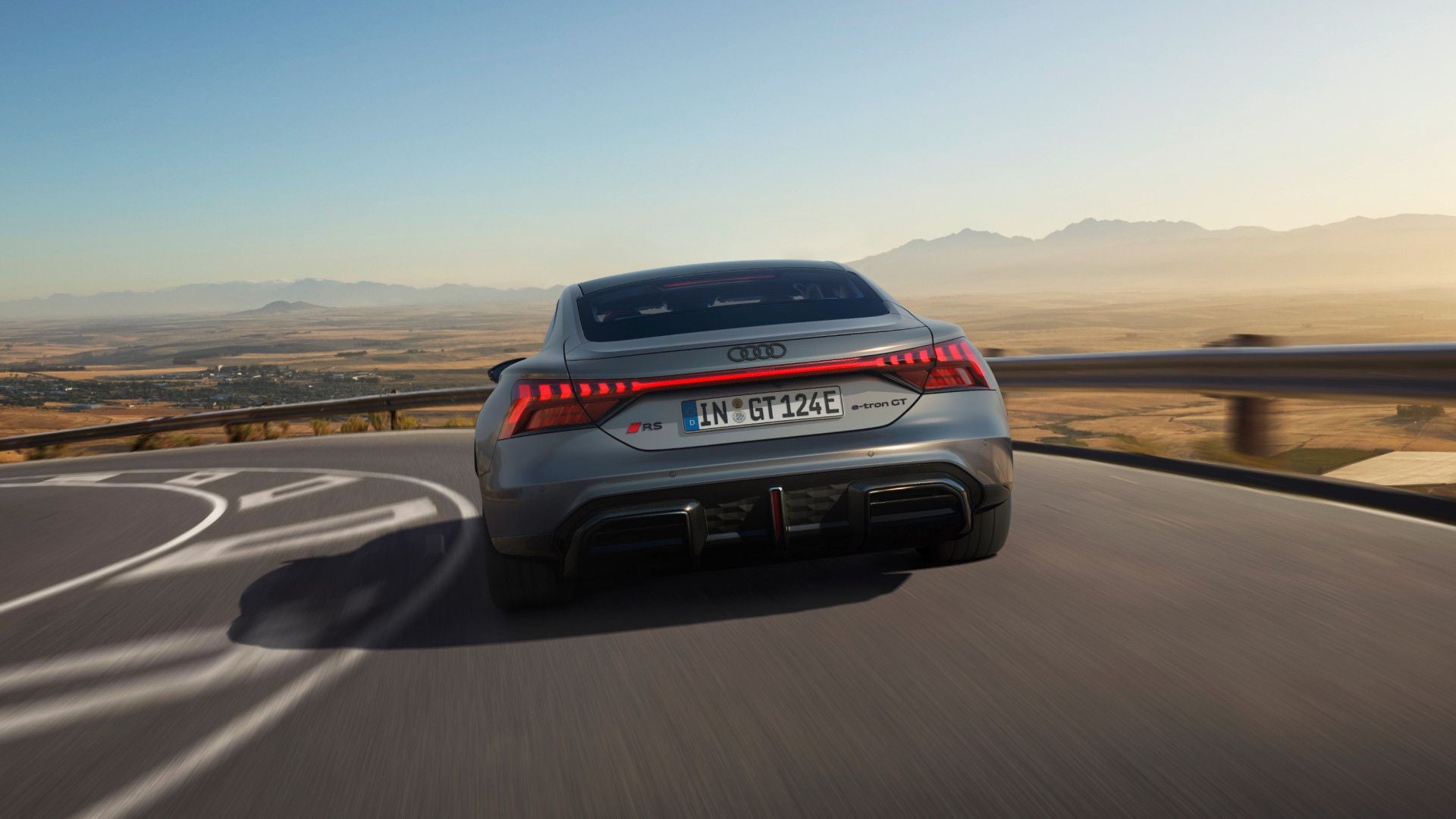 A silver Audi e-rton GT on motion in a curved road