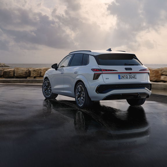 Audi Q3 SUV e-hybrid vue arrière sur un parkingAudi Q3 SUV e-hybrid vue latérale avec Audi exclusive en violet