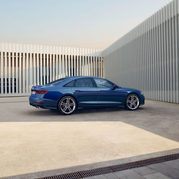 Blue Audi near corner outside with shadow