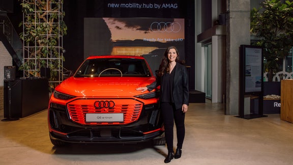 Tina Weirather im The square neben einem Roten Audi SQ6 SUV e-tron