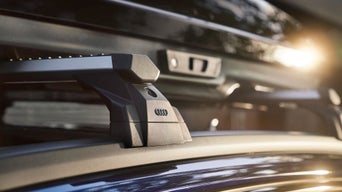 Nahaufnahme eines Audi-Dachträgers bei Sonnenlicht, montiert auf glänzendem Fahrzeugdach.