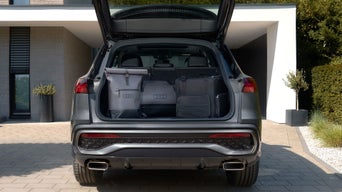 Offener Kofferraum mit einem Audi Rucksack, Tasche und Kühlbox darin
