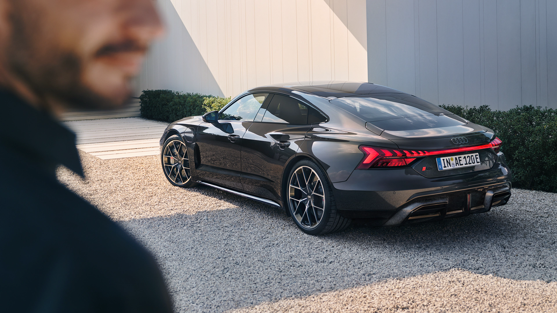Black Audi RS e-tron GT with red taillights and black wheels parked on gravel