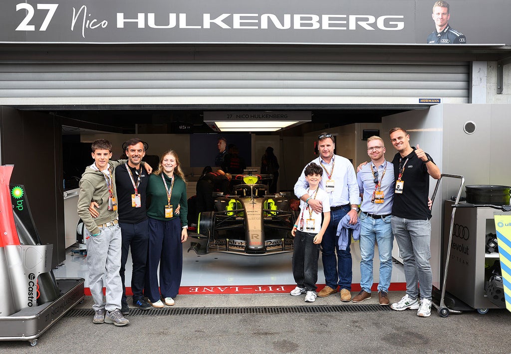 Invités Audi posant devant le garage de Nico Hülkenberg et la monoplace Audi Revolut F1® à Spa-Francorchamps 2026