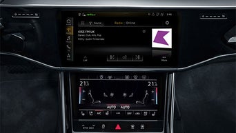 Mittelkonsole mit Display zeigt Radiosender KISS FM UK und darunter die Klimaautomatik mit 21,5 °C auf beiden Seiten.
