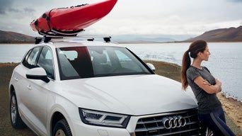 Kvinne lener seg inntil Audi