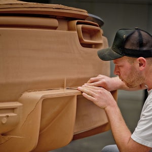 Een medewerker werkt aan een houten model van de Audi Nuvolari.