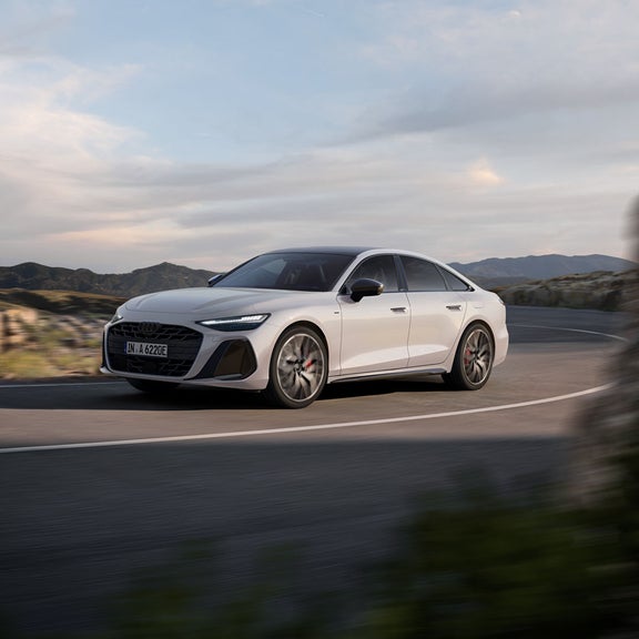 Vorderes Seitenprofil der A6 Limousine e-hybrid, welche um eine Kurve fährt.