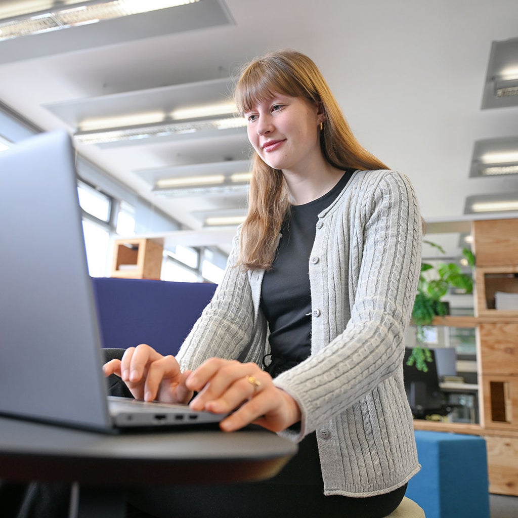 Josee schaut auf einen Laptop vor sich