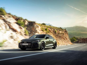 The RS 5 Sedan in a slanted profile from behind on a dark background.