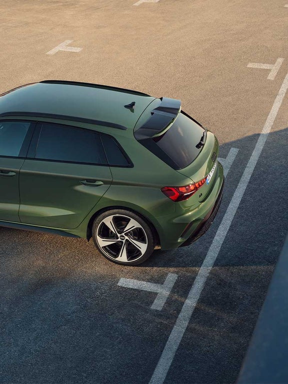 Grüner Audi A3 Sportback von oben rechts fotografiert, geparkt auf einem Asphaltparkplatz mit sichtbaren weißen Markierungen.