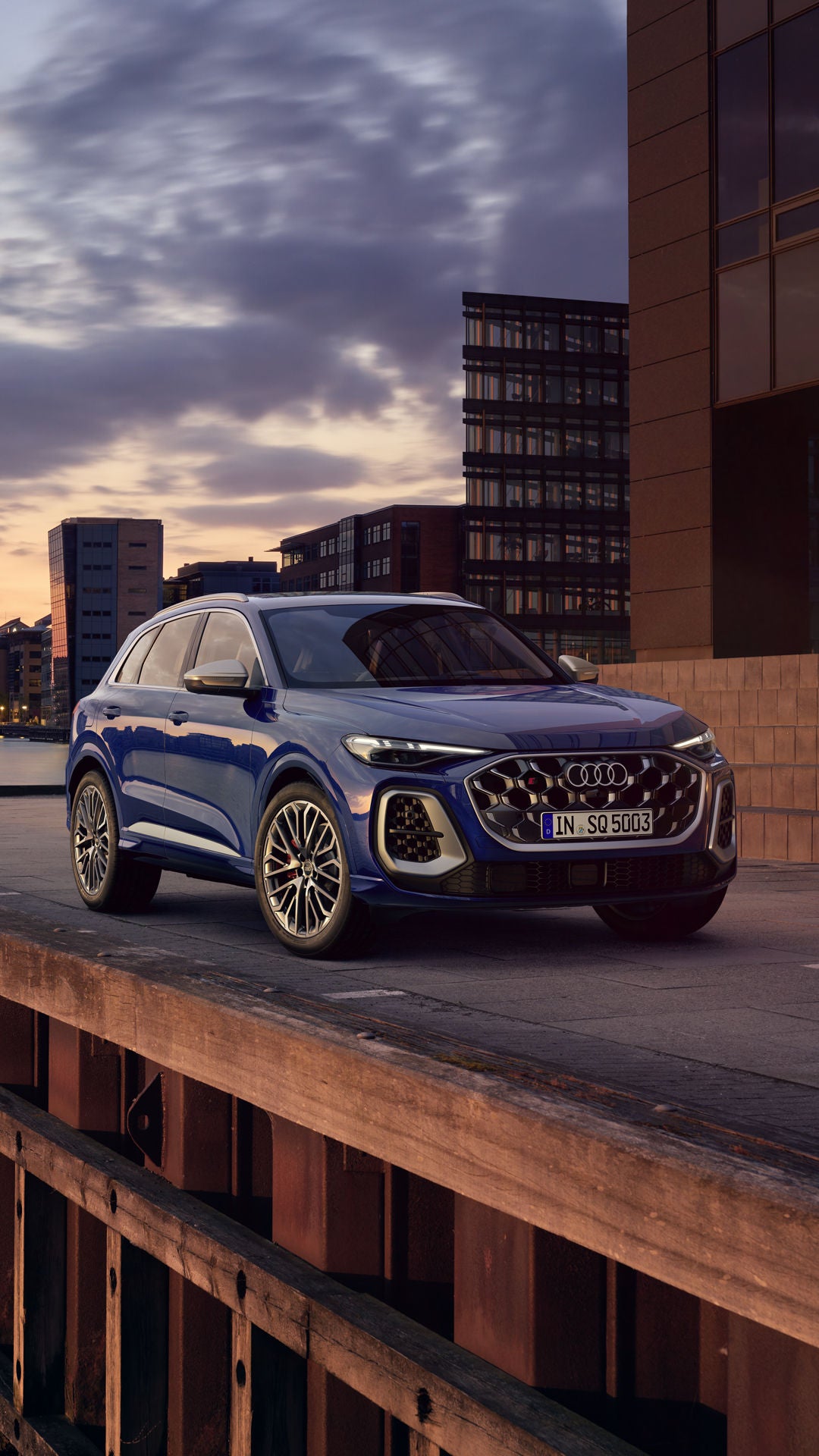 Der SQ5 SUV steht bei Sonnenuntergang vor der Skyline einer Küstenstadt.&nbsp;