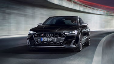 A black car driving on a curved road with motion blur effect.