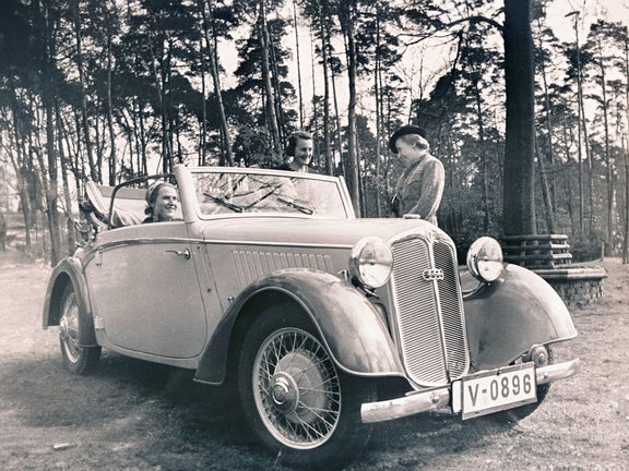 Schwarz-weiß-Aufnahme von einer Frau, die im DKW F 5 sitzt und zwei Frauen, die daneben stehen