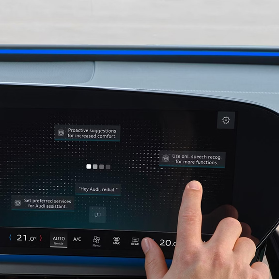 An Audi vehicle parked on a roadside with mountainous terrain in the background