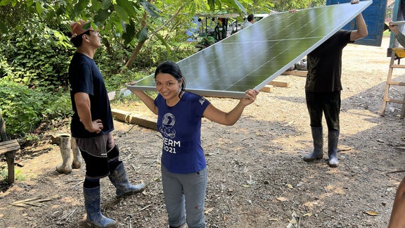 Helpers carry solar panels