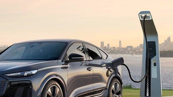 An Audi car plugged into an external EV charger