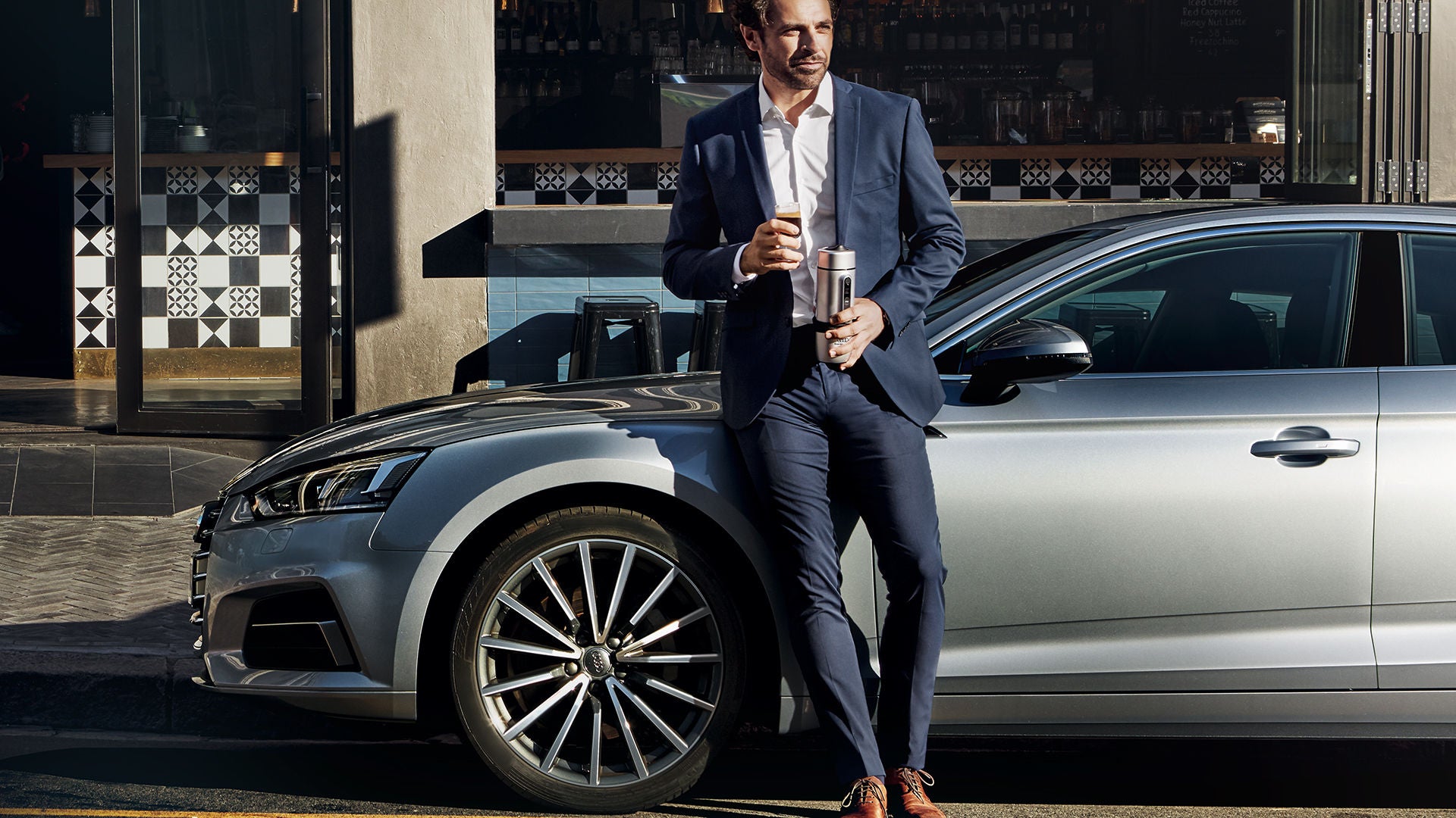 Rear view of an Audi car with a red wall background