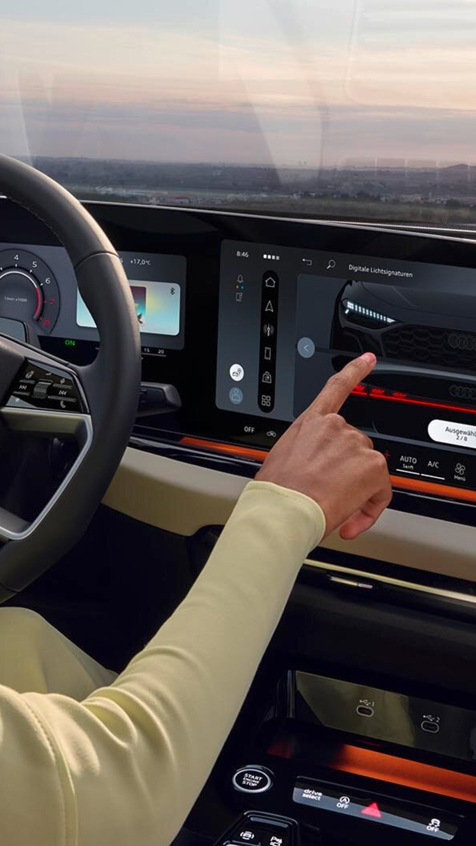 A woman in the driver's seat of an Audi car selecting a setting from the digital dashboard