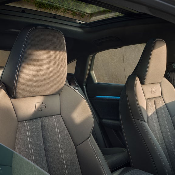 Die vorderen beiden Sitze des Q6 Sportback e-tron aus der Perspektive des halb geöffneten Beifahrerfensters.