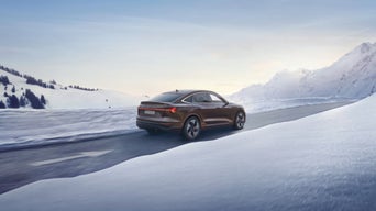 Ein Audi fährt in einer Schneelandschaft