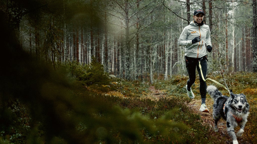 Lisa i skogen med hunden Leo under en av många träningsrundor nära hemmet i Roslagen.
