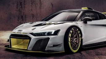 White Audi R8 LMS GT2 with yellow accents, parked in front of a textured wall