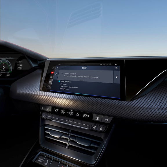 Car dashboard displaying Amazon Alexa interface, with example voice commands.
