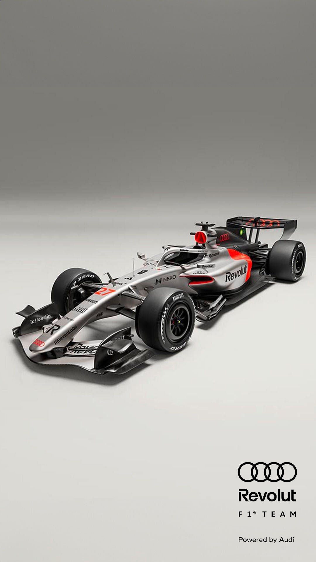 Schrägansicht eines silber-schwarzen Formel-1-Rennwagens mit roten Akzenten vor grauem Hintergrund, Audi- und Revolut-Logo in schwarz am Rand.