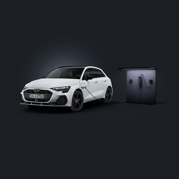 An Audi A3 Sportback e-hybrid, viewed from the front at an angle against a dark background, connected to the e-tron compact charging system.
