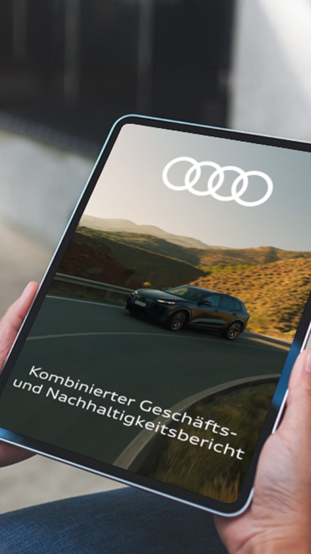 Eine Frau hält ein Tablet mit der Schrift Kombinierter Geschäfts- und Nachhaltigkeitsbericht in den Händen