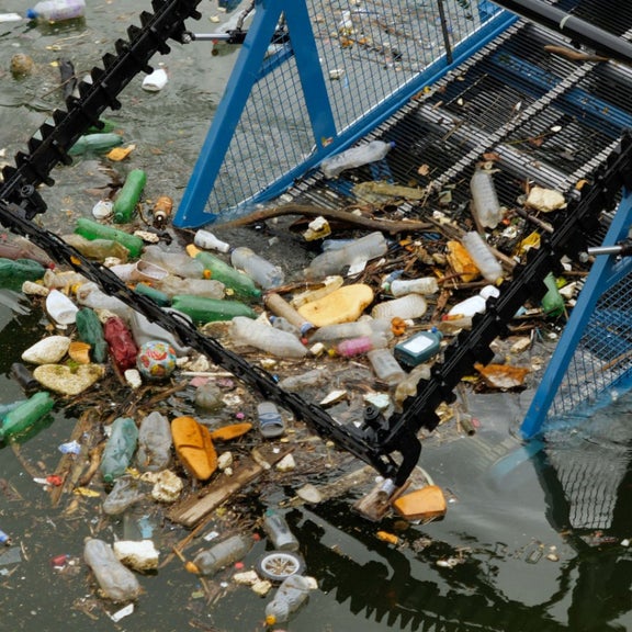 Machine lifts rubbish out of a river.