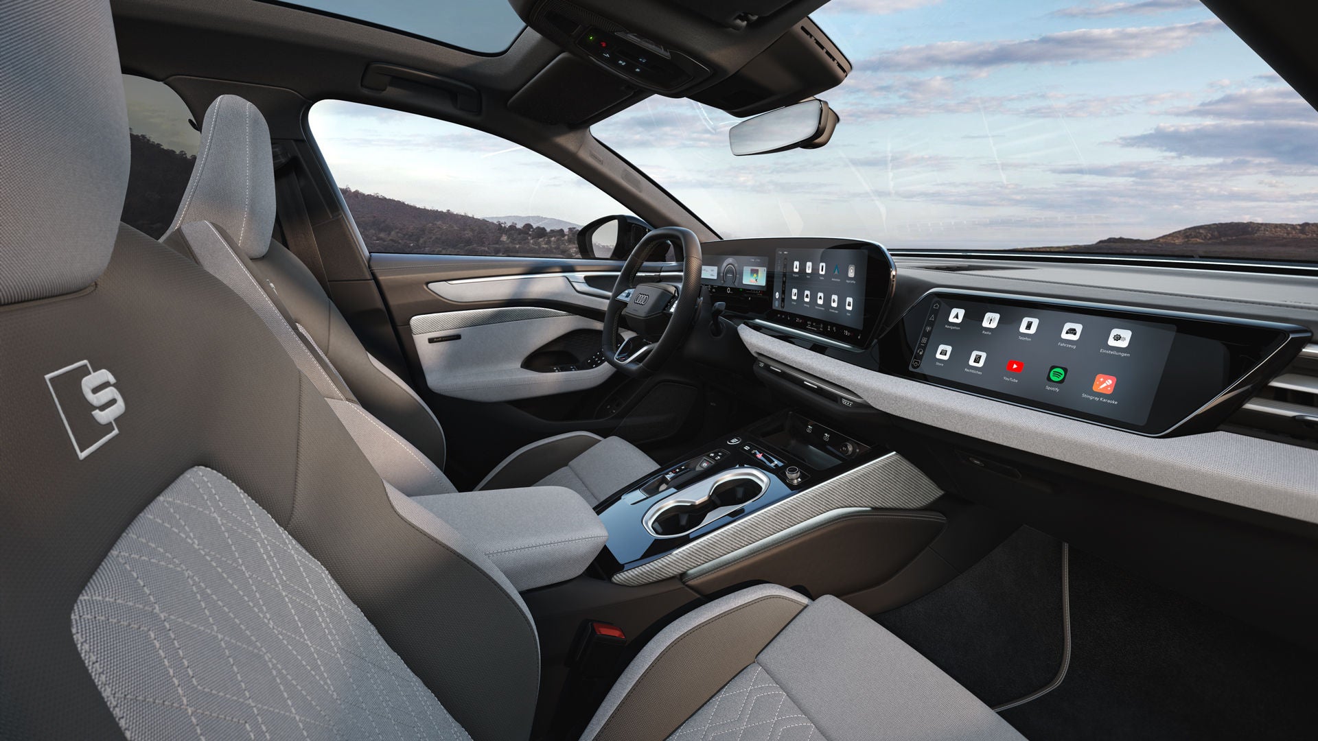 The interior of the A6 Saloon e-hybrid from the passenger's perspective, B-pillar. The focus is on the sports seats in light gray-neodymium gold fabric with decorative inserts in light gray linen fabric.