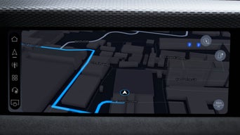 Navigationsanzeige auf dem Audi-Display mit 3D-Kartenansicht eines Stadtgebiets entlang eines Flussufers.
