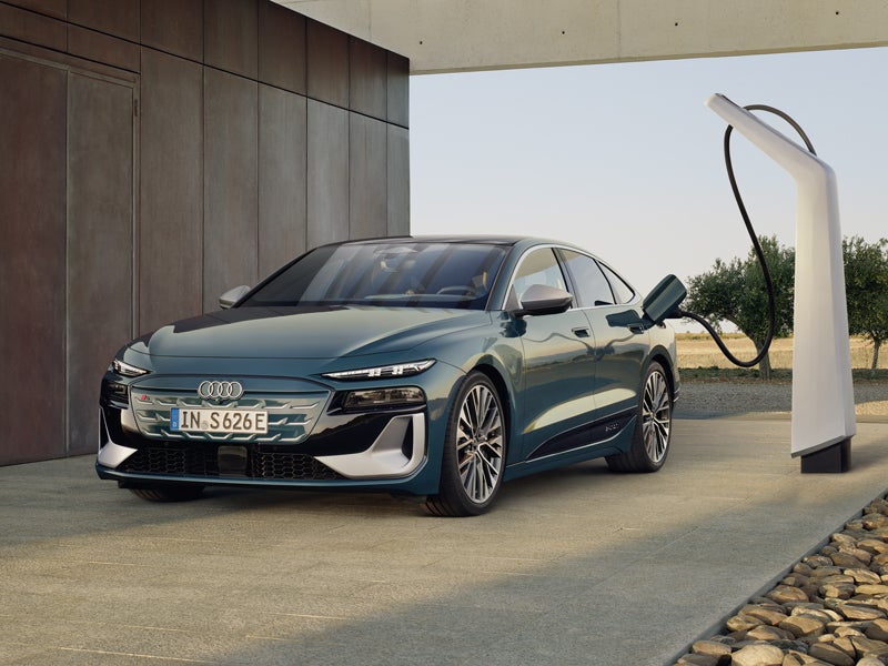 Der S6 Sportback e-tron im schrägen Frontprofil, während er an eine Ladestation angeschlossen ist.