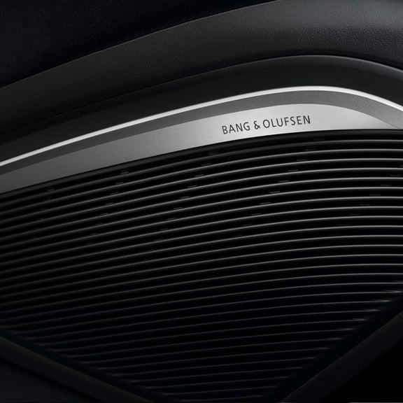 Close-up of a Bang & Olufsen speaker grille in a car interior.