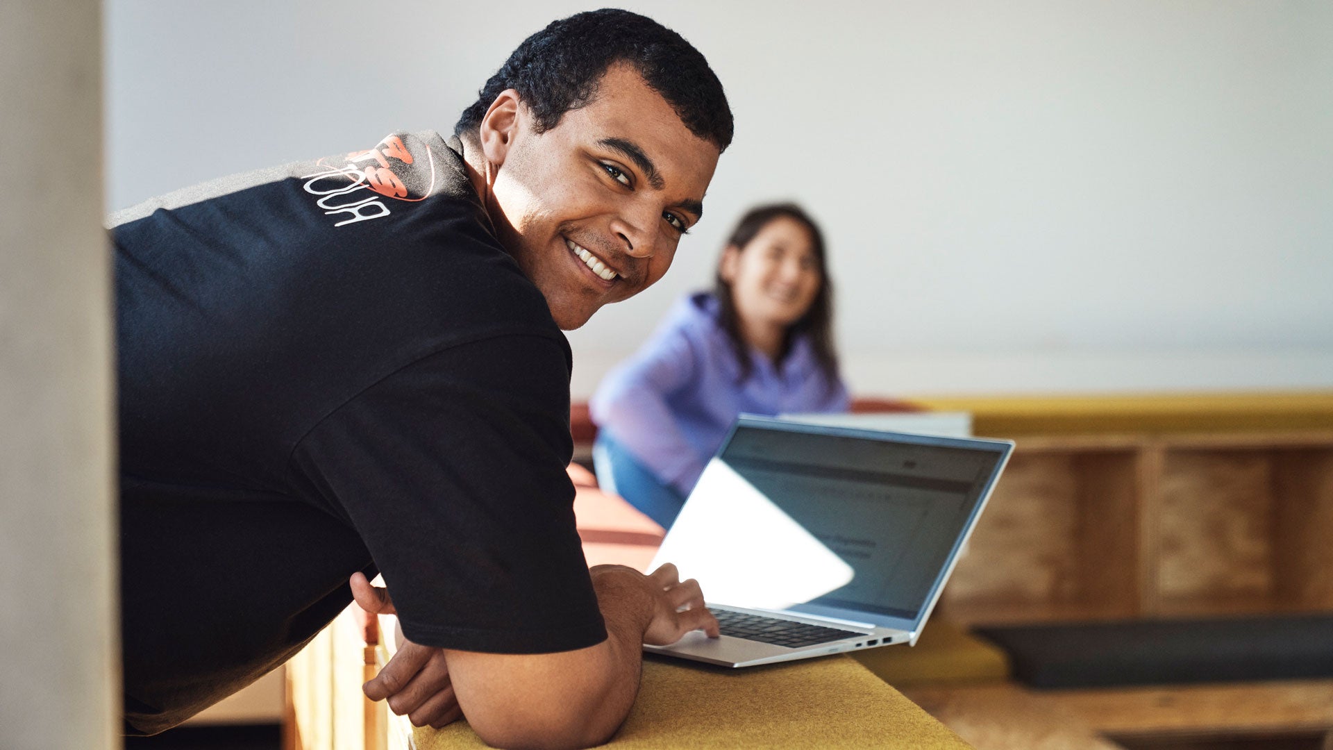 Cheerful Audi employee looking over his shoulder at an informal meeting at a standing bar