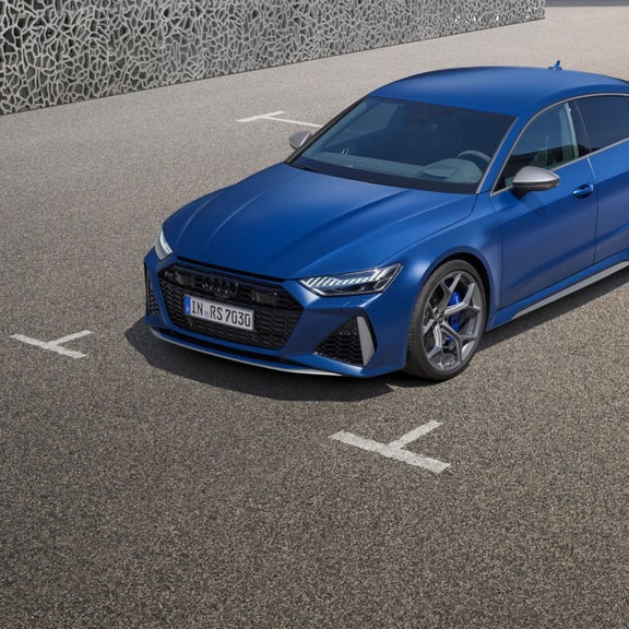 Blue car parked on asphalt with visible front license plate.