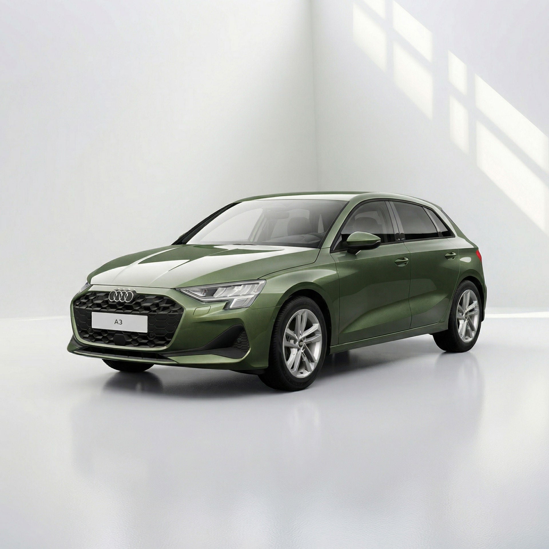 Ein dunkelgrüner, moderner Kombi steht in einem hellen Studio. Das Fahrzeug ist schräg von vorne dargestellt, vor einem neutralen, weißen Hintergrund.