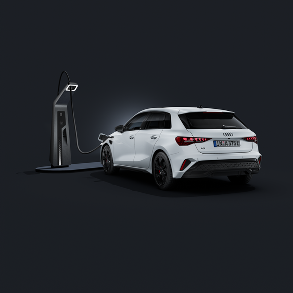 An Audi A3 Sportback e-hybrid, viewed from the rear at an angle against a dark background, connected to a fast-charging station.