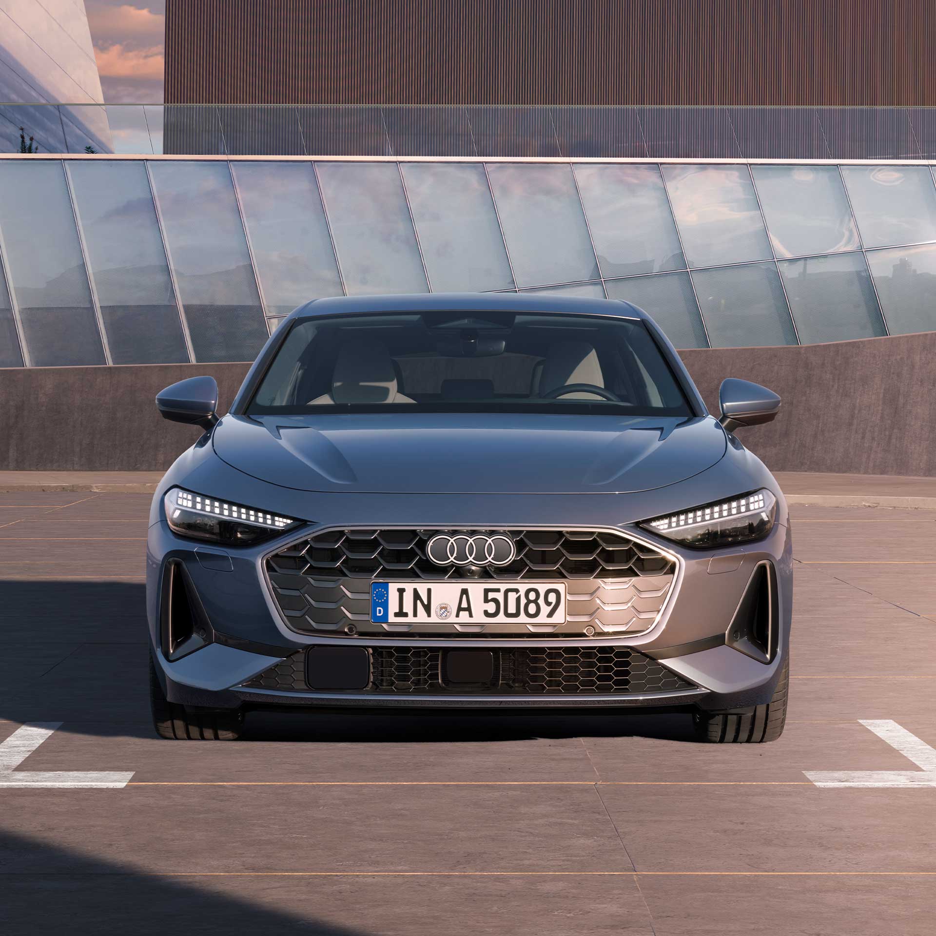 Die A5 Limousine steht im Frontprofil auf einem Parkplatz.