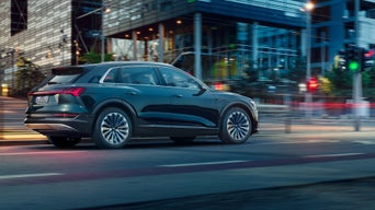 The S6 Sportback e-tron is shown in a slightly angled side view in front of a modern house.