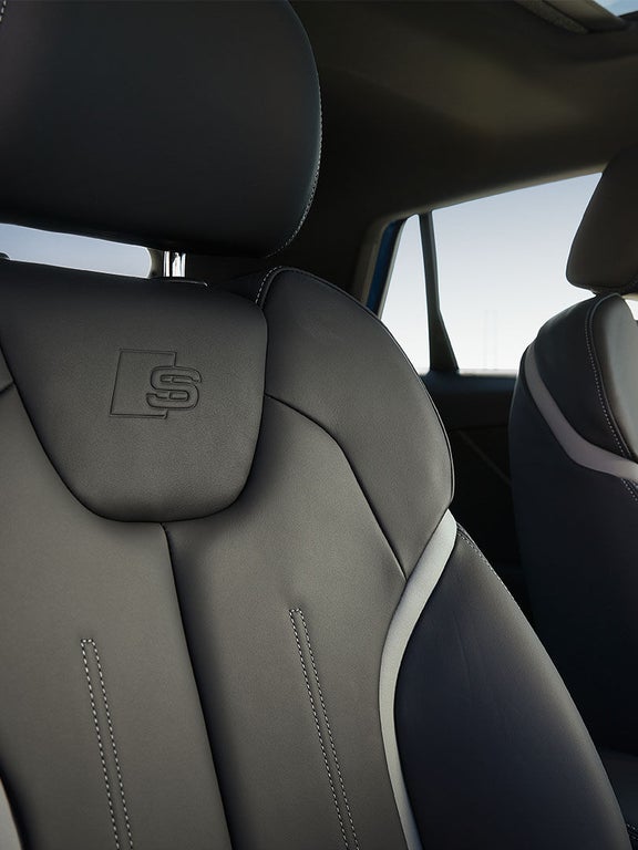 Zwei schwarze Sportsitze mit geprägtem S-Logo im Audi Q2, leicht seitlicher Blick.