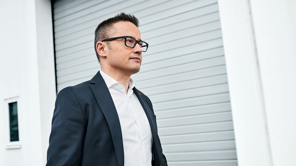 Fermín Soneira Santos in front of a gate on the company grounds.