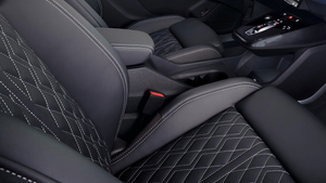 Dark grey Audi Q4 e-tron car seats with white stitching and diamond patterned centre, gearstick and centre console visible.