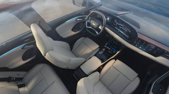 Blick von oben in den Innenraum eines Audi mit zwei vorderen Sitzen, digitalem Cockpit und Mittelkonsole.