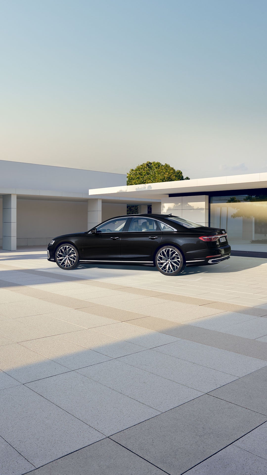 Schwarzer Audi A8 steht vor einem modernen, hellen Gebäude bei Tageslicht.