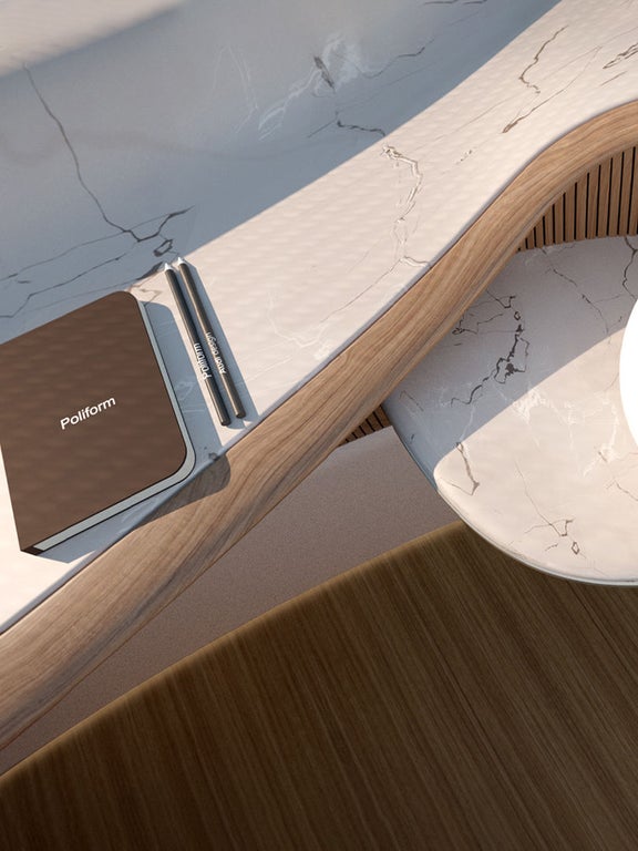Sur une table du design intérieur de Poliform, pour le concept Audi ur-bansphere, se trouve un bloc-notes avec un stylo et une lampe ronde.