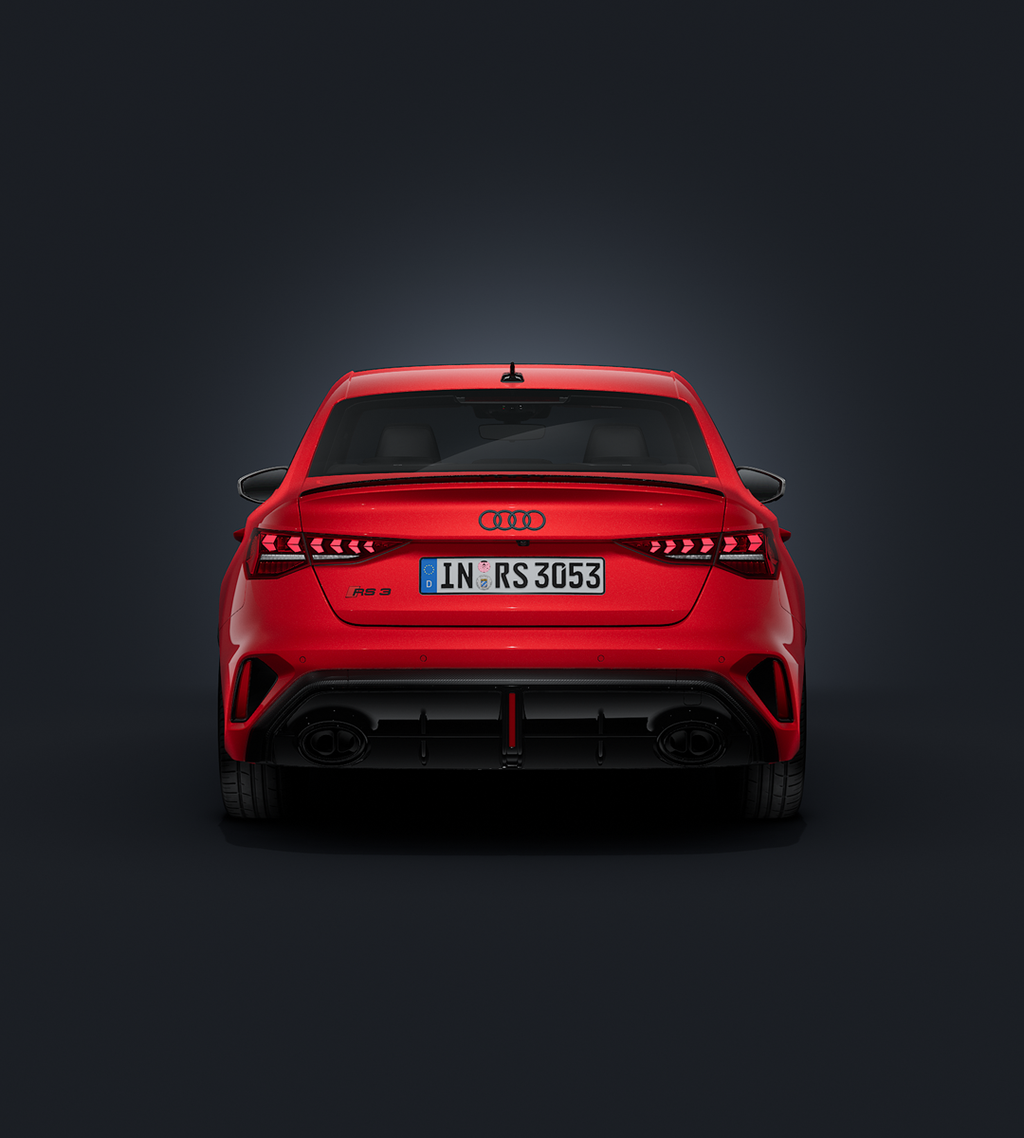 De Audi RS 3 Berline, van voren en van achteren gezien tegen een donkere achtergrond.